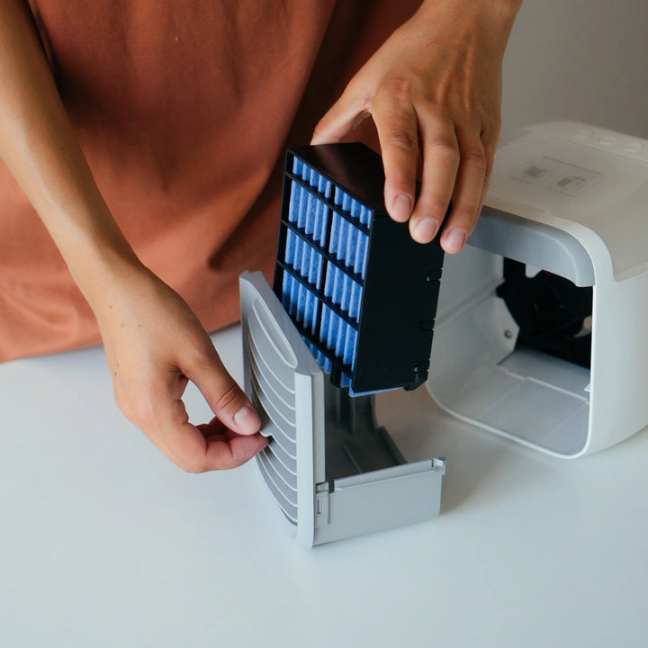 Person inserting a blue filter into the air cooler